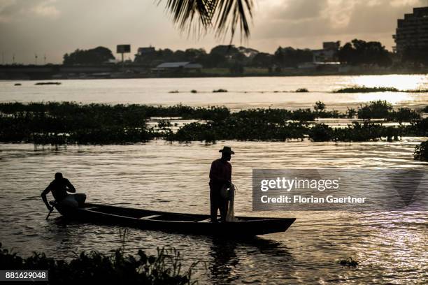 Two fishermen fish at the Ebrie Lagoon on November 28, 2017 in Abidjan, Ivory Coast.