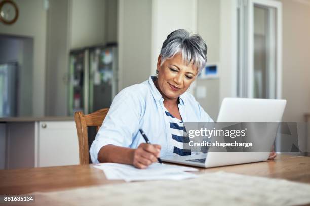 she's budgeted well - mature adult on computer stock pictures, royalty-free photos & images