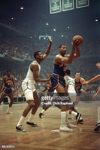 Wilt Chamberlain of the San Francisco Warriors posts up against Bill Russell of the Boston Celtics during a game played in 1964 at the Boston Garden...