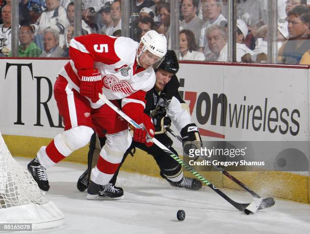 Nicklas Lidstrom of the Detroit Red Wings fights for the puck against Jordan Staal of the Pittsburgh Penguins during Game Three of the 2009 NHL...