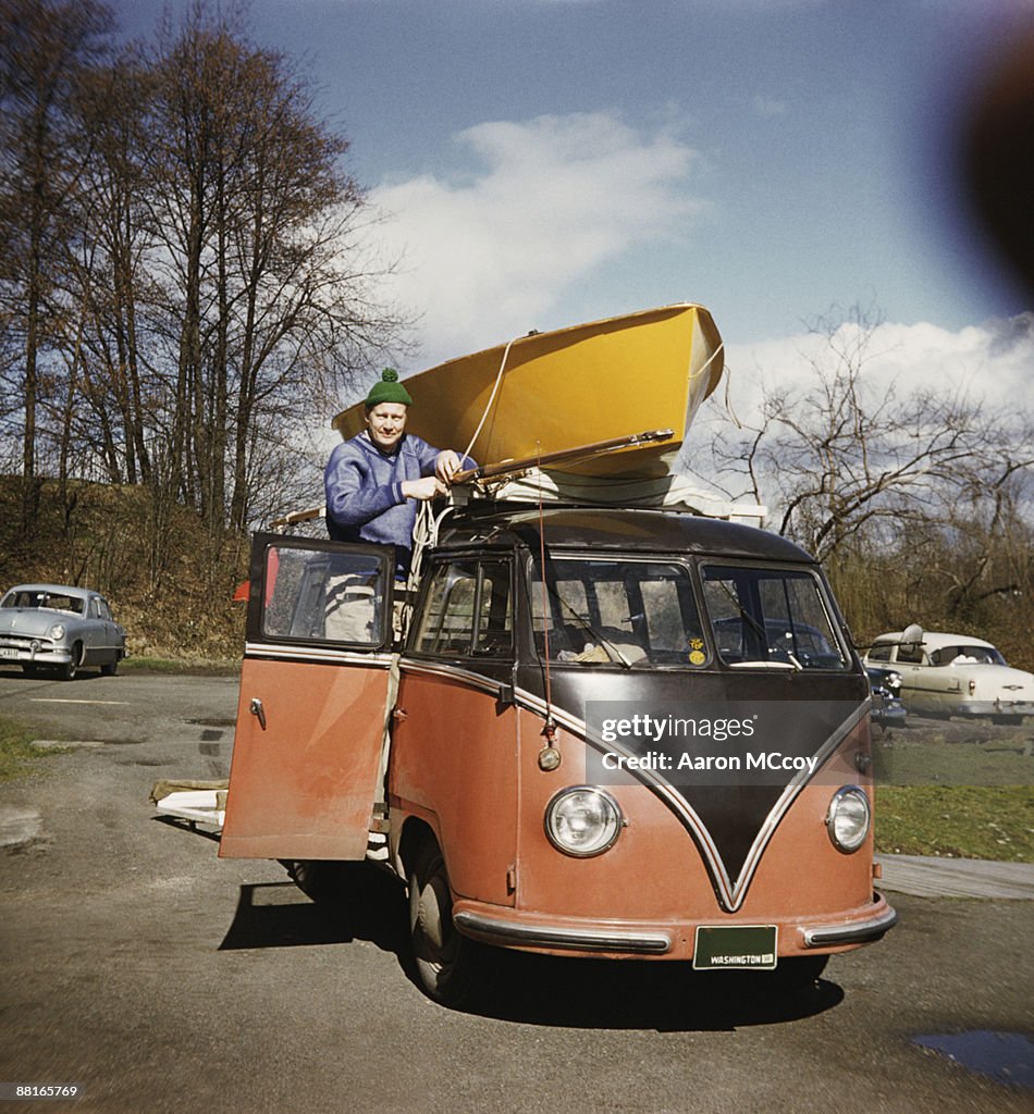 Man tying boat to van