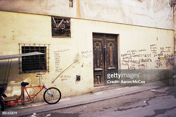 "bike parked in front of graffiti covered wall, cuba" - havana door stock pictures, royalty-free photos & images