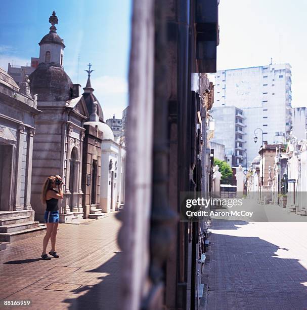 woman taking picture of mausoleums, buenos aires, argentina - la recoleta cemetery stockfoto's en -beelden