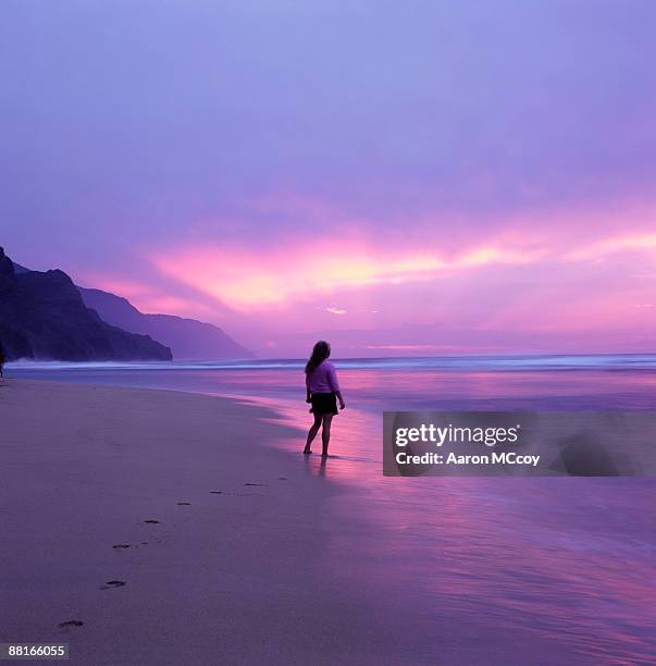 "woman on beach at sunset, kauai, hawaii" - beach sand and water hawaii stock-fotos und bilder