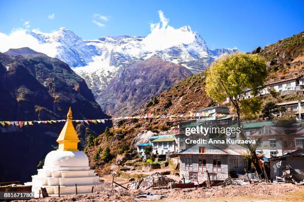 the beautiful landscape with the old buddhist stupa and the snow mountains on the background in the village namche bazaar in himalayas, nepal - bazar namche imagens e fotografias de stock