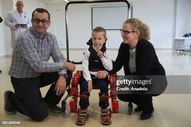 Jens, a 5 year-old boy diagnosed with spinal muscular atrophy , gestures as he walks with a new Marsi Bionics exoskeleton that designed for disabled...
