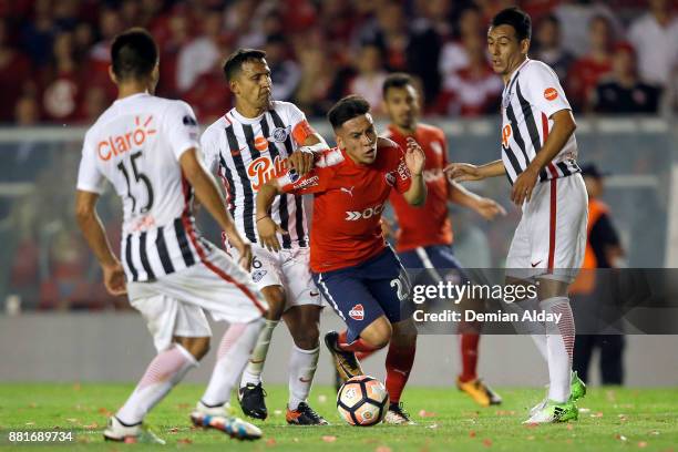Ezequiel Barco of Independiente fights for the ball with Sergio Aquino of Libertad during a second leg match between Independiente and Libertad as...