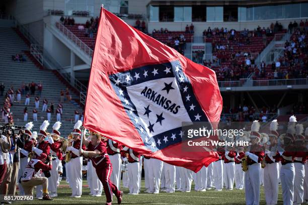 Cheerleader of the Arkansas Razorbacks runs the Arkansas State flag onto the field before a game against the Missouri Tigers at Razorback Stadium on...