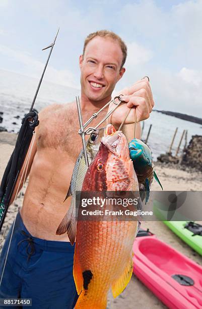 smiling man with fish and spear gun - harpun bildbanksfoton och bilder