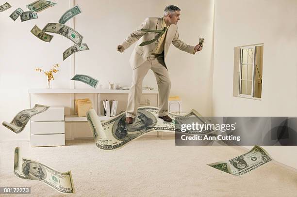 businessman flying on dollar bill - 空飛ぶ絨毯 ストックフォトと画像