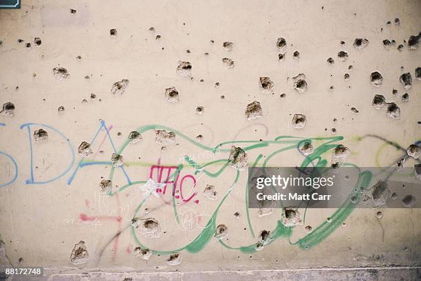bullet holes in wall with graffiti - bullet hole stock pictures, royalty-free photos & images