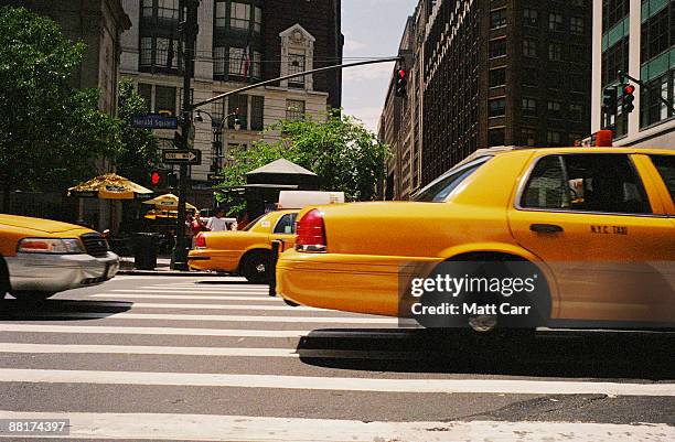 midtown manhattan street with taxis - taxi van stockfoto's en -beelden