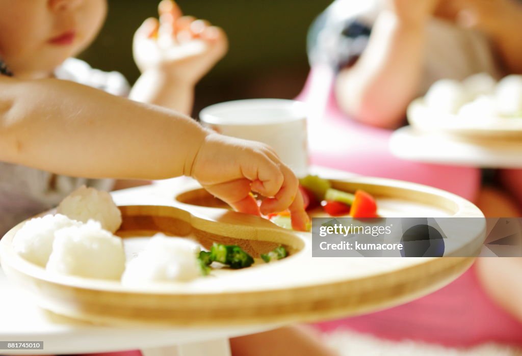 Little child eating meal with bare hands,close up