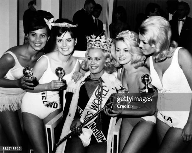 Lesley Langley from England fanked by , Miss Tahiti, Miss Ireland, Miss USA and Miss Austria reacts after being crowned Miss World 1965 on November...