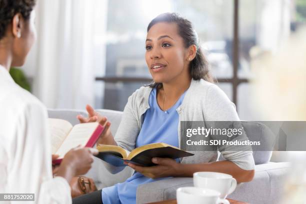 african american woman participates in bible study with her friend - trust god stock pictures, royalty-free photos & images