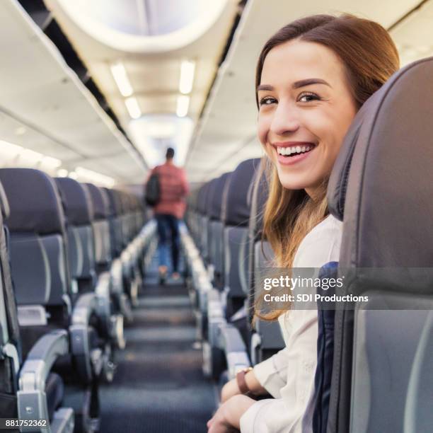 attraktive junge frau kaukasischen wartet flugzeug aussteigen - aisle seat airline stock-fotos und bilder