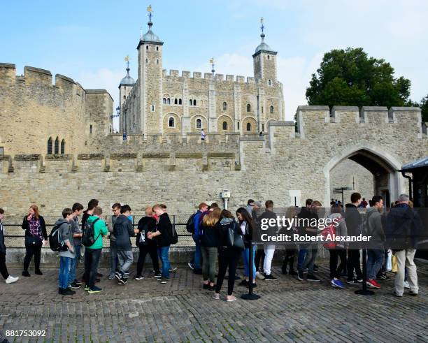 High school students visiting London, England, stand in line at an entrance to the Tower of London, officially Her Majesty's Royal Palace and...