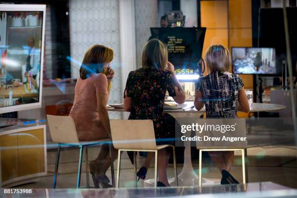 Hoda Kotb, Savannah Guthrie and Dylan Dreyer sit at a table during a break on the set of NBC's Today Show, November 29, 2017 in New York City. It was...