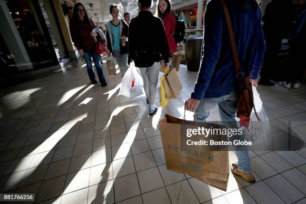 Shoppers leave the new Primark store at The Burlington Mall in Burlington, MA on Black Friday, Nov. 24, 2017.