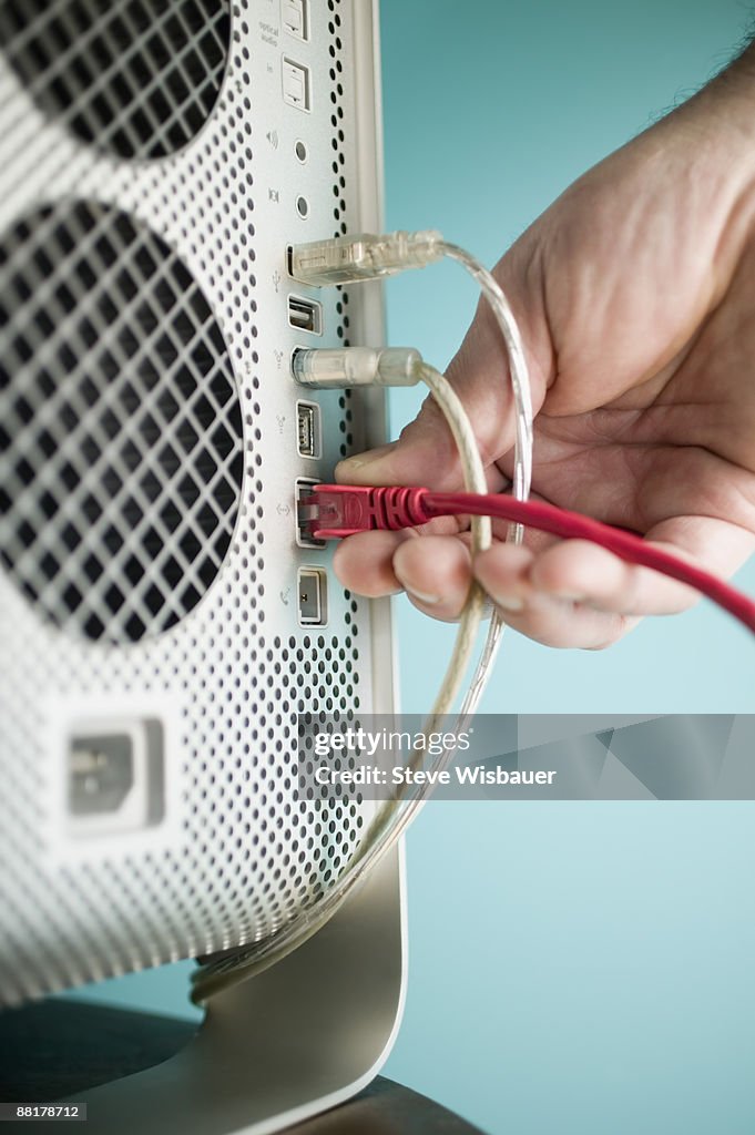 Hand plugging cable into computer port