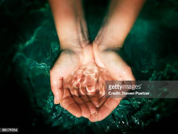 pair of hands cupping water - spring flowing water stock pictures, royalty-free photos & images