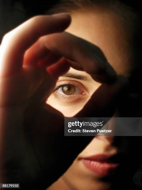 woman looking through circled fingers - 3 wise monkeys stock pictures, royalty-free photos & images