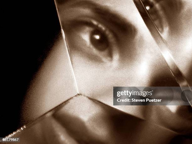 woman's face reflected in shards of broken glass - haut empfindlich stock-fotos und bilder