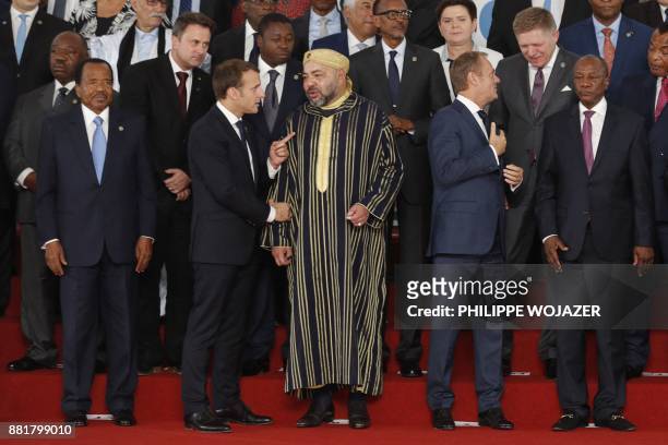 French President Emmanuel Macron speaks with King Mohammed VI of Morocco , next to Cameroon's President Paul Biya and European Council President...