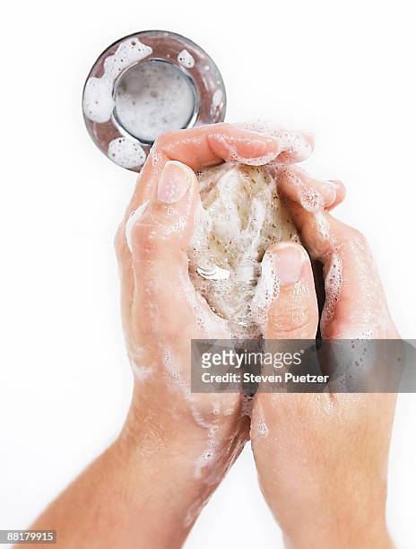hands holding bar of soap over sink drain - seifenstück stock-fotos und bilder