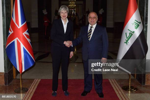 British Prime Minister Theresa May and Iraqi Prime Minister Haider Al-Abadi pose for photographs ahead of a bi-lateral meeting in the Government...