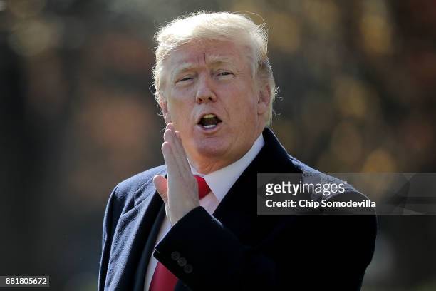 President Donald Trump shouts at journalists from across the South Lawn as he departs the White House November 29, 2017 in Washington, DC. Trump is...
