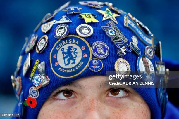 Young Chelsea fan wearing a badge-covered hat waits for kick off in the English Premier League football match between Chelsea and Swansea City at...