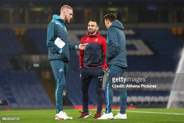 Team mate Tom Carroll and Leon Britton of Swansea City speak prior to kick off of the Premier League match between Chelsea and Swansea City at...