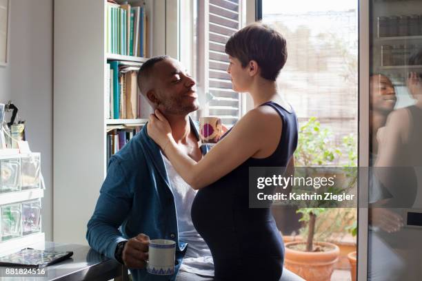 Pregnant couple having tea together in kitchen