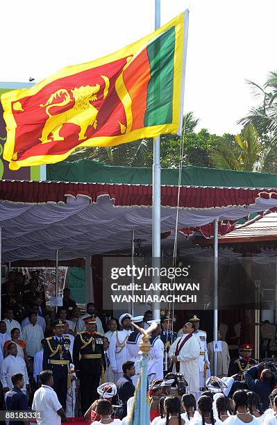 Sri Lankan president Mahinda Rajapakse hoists the national flag during the National Military Victory Celebration in Colombo on June 3, 2009. Sri...