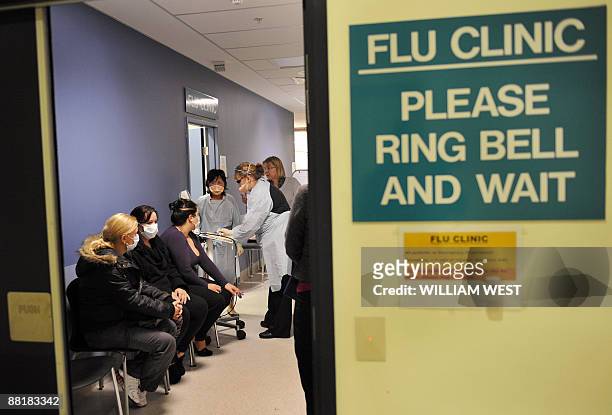 People wait at a swine flu clinic in Melbourne's Austin Hospital as Australia raised the swine flu alert level in the worst hit state of Victoria and...