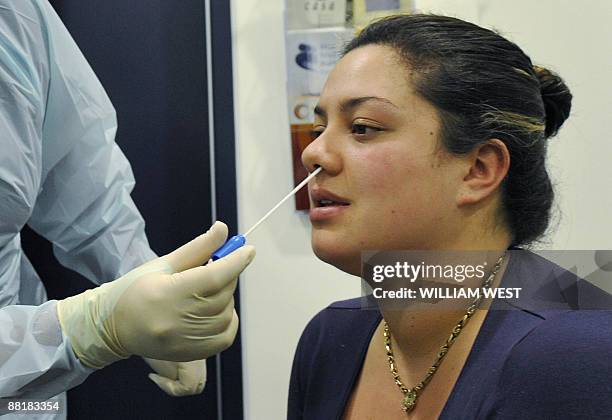 Alyssa Tumai is tested by nurse Michele Rowe at a swine flu clinic in Melbourne's Austin Hospital as Australia raises the swine flu alert level in...
