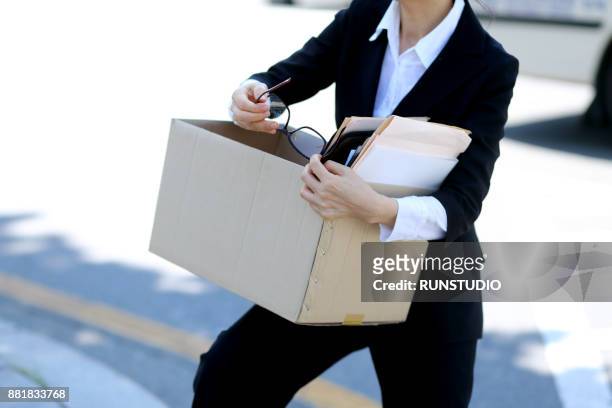 close-up of businesswoman holding glasses and box of personal items - downsizing 2017 film stock-fotos und bilder