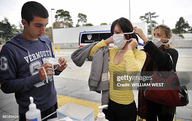 People put on masks as they arrive at Melbourne's Austin Hospital as Australia raised the swine flu alert level in the worst hit state of Victoria...