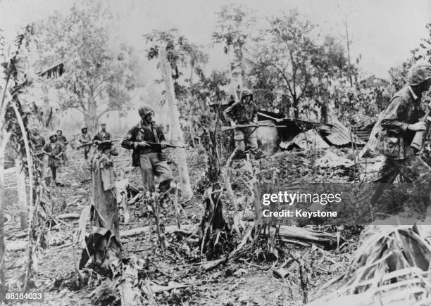 Marines advance through Japanese positions on Saipan Island after the Battle of Saipan in the Northern Mariana Islands, 14th July 1944.