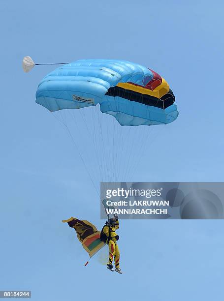 Sri Lankan paraglider, carrying the national flag, lands during the National Military Victory Celebrations in Colombo on June 3, 2009. Sri Lanka's...