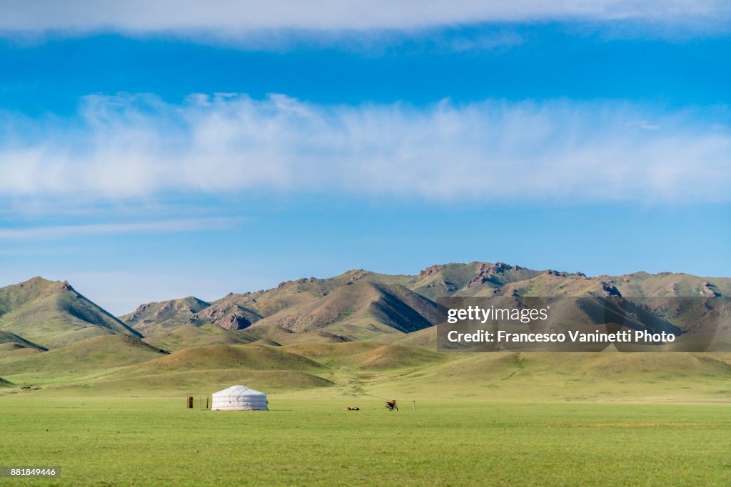 Nomadic ger, motorbike and mountains in the background. Bayandalai district, South Gobi province, Mongolia.