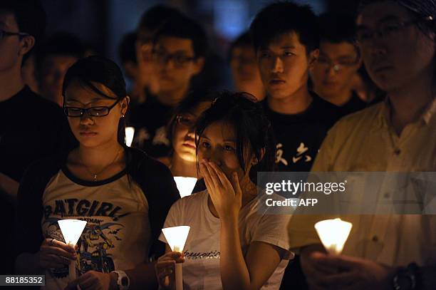 Students from the University of Hong Kong hold a candlelight vigil next to the The Pillar of Shame - a statue to mark the Beijing Tiananmen...