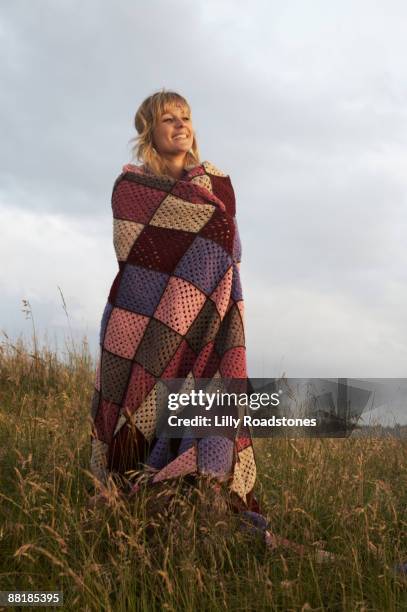 young woman standing on hillside - patchwork stockfoto's en -beelden