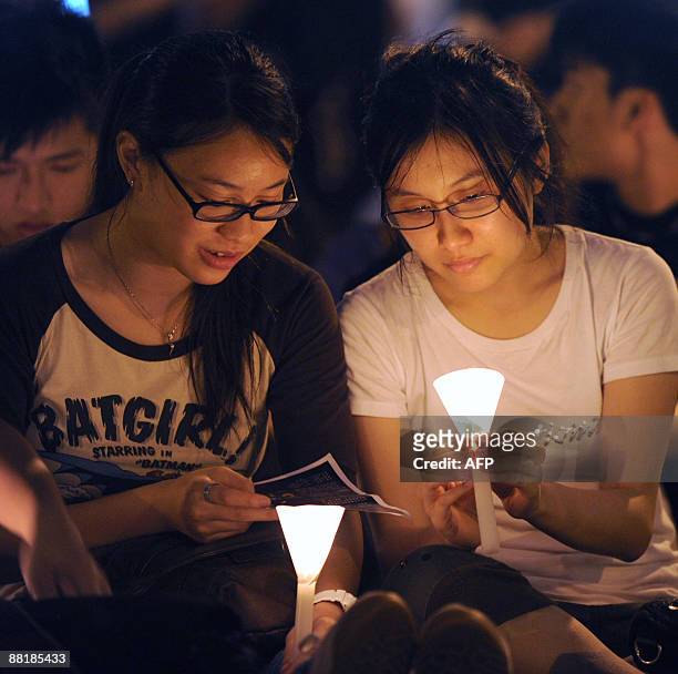 Students from the University of Hong Kong hold a candlelight vigil next to the The Pillar of Shame - a statue to mark the Beijing Tiananmen...