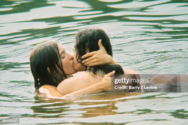 An unidentified couple kiss while mostly submerged under water in a lake on the grounds of the Woodstock Music and Arts Fair in Bethel, New York,...