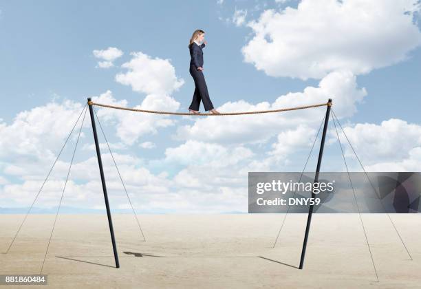 businesswoman balancing on tightrope - woman tightrope stock pictures, royalty-free photos & images
