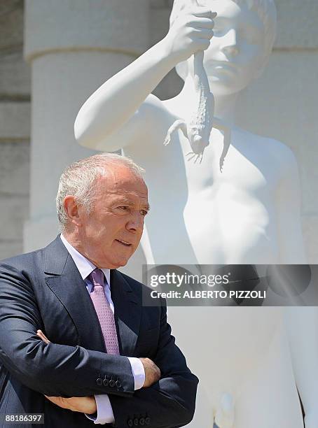 French businessman Francois Pinault poses with "The Boy with the frog" by US artist Charles Ray in front of the Punta della Dogana in Venice during...