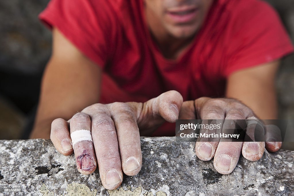 Rock climber clinging to cliff face