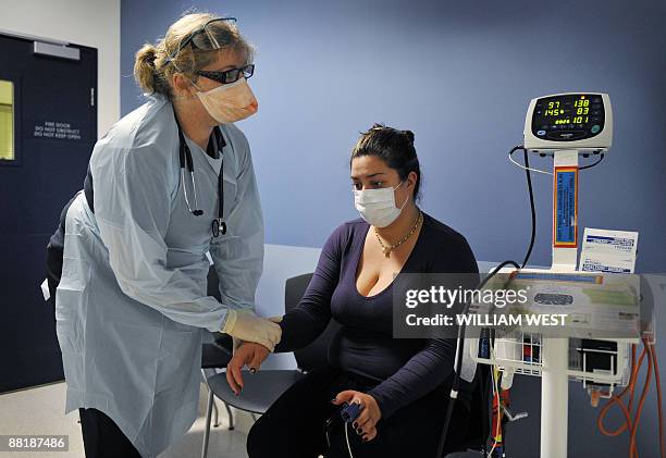 Alyssa Tumai is tested by nurse Michele Rowe at a swine flu clinic in Melbourne's Austin Hospital as Australia raises the swine flu alert level in...